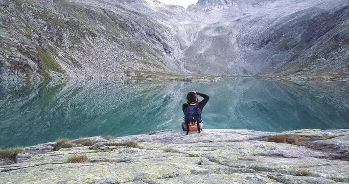 Woman taking photo of the lake in the Austrian mountains. 4k