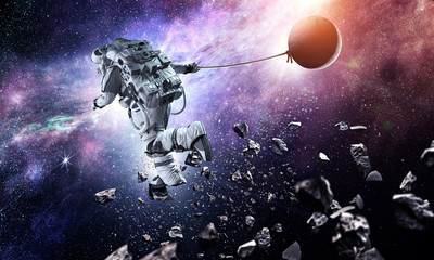 Obraz na płótnie Canvas Fantasy image with spaceman catch planet. Mixed media