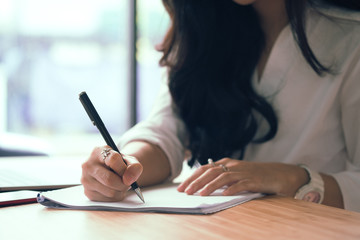 businesswoman writing on paper at workplace. young female entrepreneur woman handwriting note at office. paperwork on table.