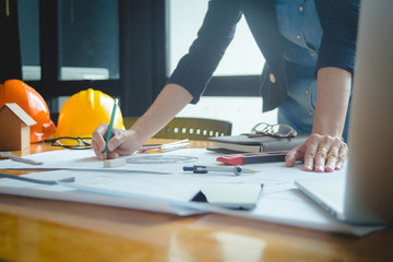 Architect woman using pencil and vernier caliper working with blueprint on desk in the office for architectural plan,engineer sketching a construction project concept. Selective focus,Vintage effect.