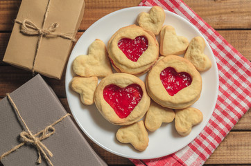 Homemade cookies in heart-shaped gifts and red paper hearts, greetings on Valentine's day, top view