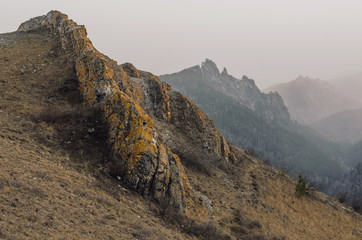 Autumn landscape - rocks and mountains, fog and clouds.