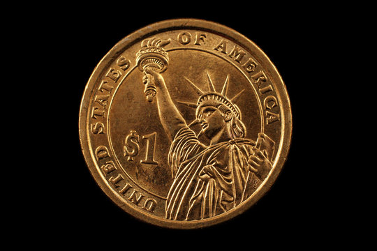 A super macro image of a gold American one dollar coin isolated on a black background