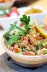 A delicious bowl of baba ghanouj with olive oil and parsley.