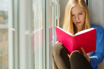 Woman reading on windowsill