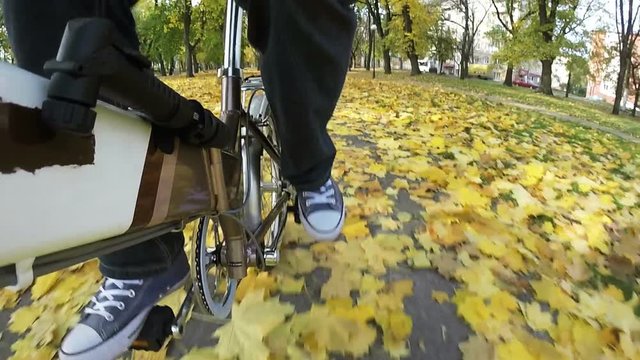 Man pedals bicycle on  autumn  city park. Point of view camera filming.