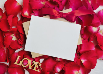Mockup Card on red rose petals for Valentine's Day. Flat lay, top view with a place for your text