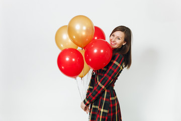 Fototapeta na wymiar Beautiful caucasian young happy woman in long plaid checkered dress with shy charming smile, red, yellow golden balloons, celebrating birthday, on white background isolated. Holiday, party concept.