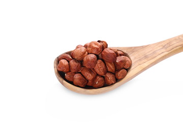 Whole hazelnuts in wooden spoon isolated on white background