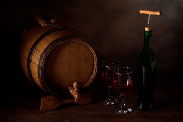  a small wooden wine bar, barrel on the legs and a wooden crane on a wooden background with a glass of wine and bottle of wine