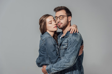 seductive sensual young couple with closed eyes hugging isolated on grey