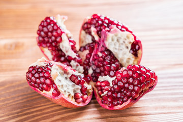 Big red pomegranate on the wooden board.  Ripe granet fruit. Broken pomegranate.