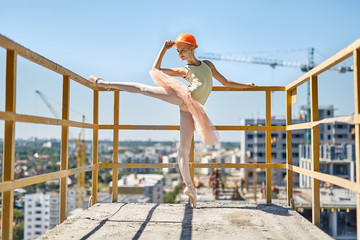 Ballerina posing at concrete balcony