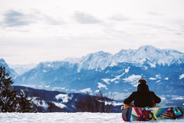 Fototapeta na wymiar Snowboarder looking at the winter landscape in Austria
