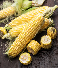 Ear of maize or corn on the dark wooden background.