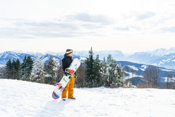 Young man standing in the snow with snowboard in Austria