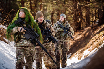 Fototapeta premium team of special forces weapons in cold forest. Winter warfare and military concept
