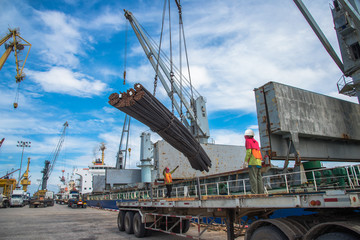 steel rod carry on lifting by the ship’s crane and lifting gears shackles, hooks, wire sling rope and chains with spreader bar, working with labor stevedore on port terminal