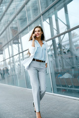 Obraz premium Beautiful Woman Talking On Phone Walking On Street.