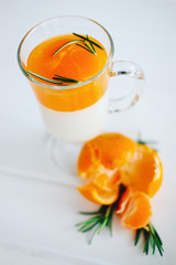 Tangerine panna cotta dessert with rosemary in wineglasses