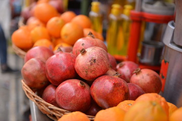 Naklejka na ściany i meble fresh juicy pomegranates and oranges in the market