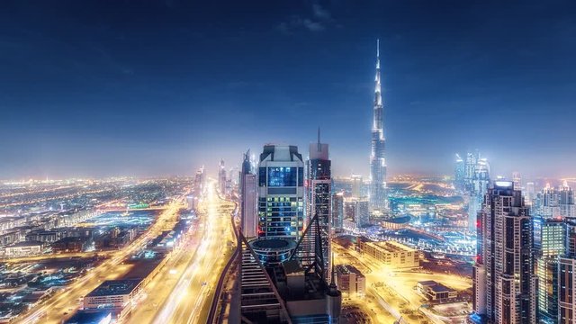 Scenic aerial view of Dubai skyscrapers and highways at night. 4K time lapse 