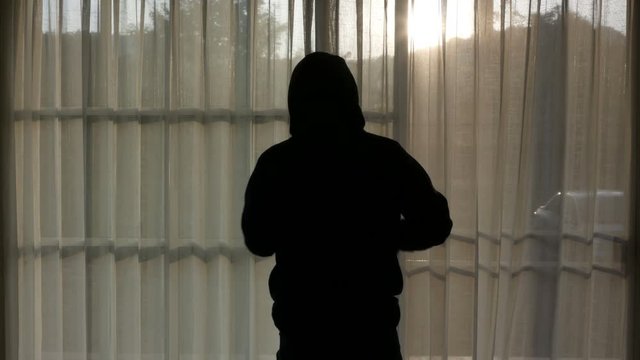 Men wear hooded sweatshirts similar to those of rappers. Open curtains in the morning.