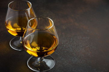 Glass of brandy or cognac on the old rusty background Selective focus Copy space