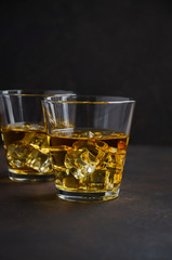 Glass of whiskey with ice on the old rusty background Selective focus Copy space