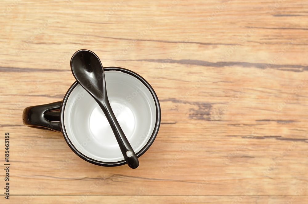 Wall mural a black mug with a black teaspoon