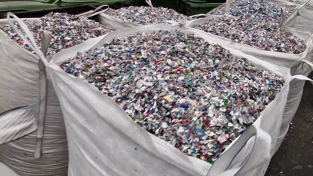 Crushed plastic bottles in the bag prepared for recycling