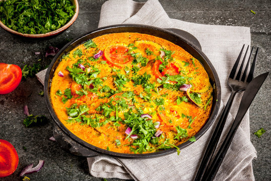 Indian food recipes, Masala Omelette with fresh vegetables - tomato, hot chili pepper, parsley, dark stone background, copy space