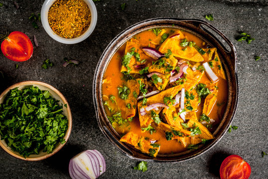Indian food recipes, Indian Omelet Masala Egg Curry, with fresh vegetables - tomato, hot chili pepper, parsley dark stone background, copy space top view