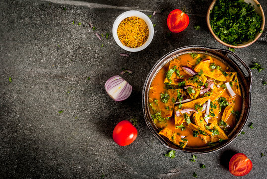 Indian food recipes, Indian Omelet Masala Egg Curry, with fresh vegetables - tomato, hot chili pepper, parsley dark stone background, copy space top view