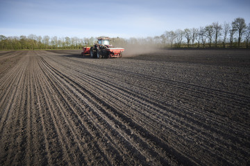 Obraz premium Red tractor plow field