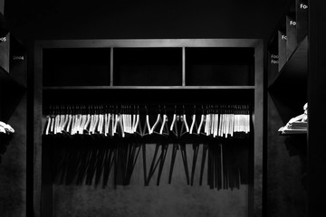 Empty wooden clothes hangers casting deep shadows, photographed in monochrome