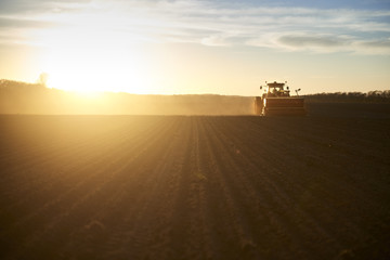 Fototapeta premium Red tractor plow field