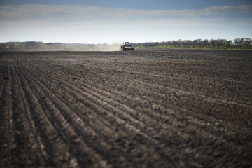Fototapeta premium red tractor plowing a field