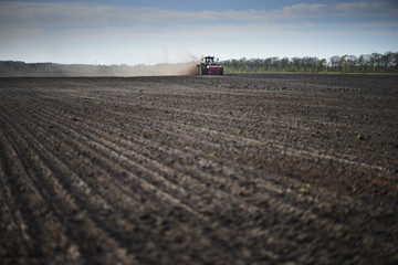 Fototapeta premium Red tractor plow field