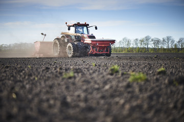 Fototapeta premium Red tractor plow field