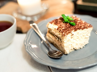 tiramisu by candlelight, romantic date in Italy, tiramisu dessert on a porcelain plate