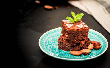 pyramid of freshly prepared home fresh brownies with nuts and figs, on a black background