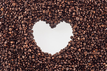 top view of heart made from roasted coffee beans on white