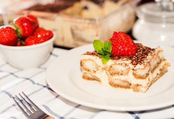 Homemade tiramisu cake decorated with strawberries Italian cuisine, Selective focus