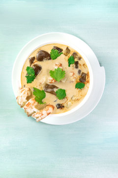 Tom Yam, traditional Thai soup with shrimps and mushrooms, on teal