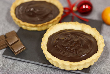 Shortcrust pastry chocolate tartlet with filling. Selective focus. Christmas concept.