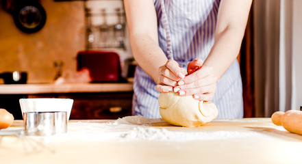 Obraz na płótnie Canvas Woman's hands knead dough on a table, for the holiday