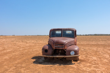 Rusty abandoned truck in arid landscape in Queensland