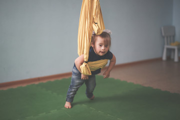 Toddler with Down syndrome  yoga, yellow hammock