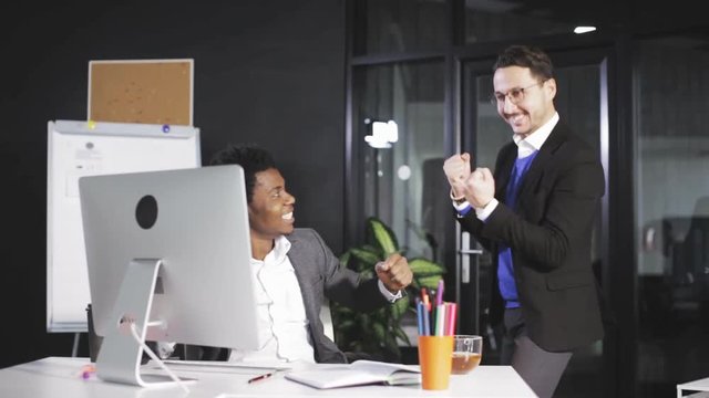 two employees raising hands when successfully closing big business deal